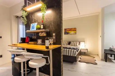 a kitchen with a bar and a living room at ROMANTIC DELUXE SVITE wise Jacuzzi and Sauna in Athens