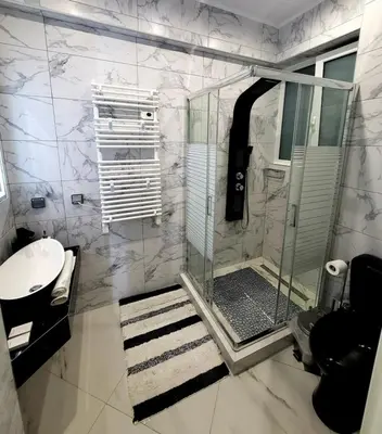 a bathroom with a shower with a glass door at ROMANTIC DELUXE SVITE wise Jacuzzi and Sauna in Athens