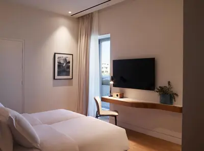 a bedroom with a bed and a desk with a tv at xenodocheio Milos in Athens