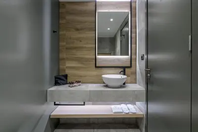 a bathroom with a sink and a mirror at Acropolis Magenta Luxury Suites in Athens