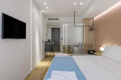 a hotel room with a bed and a flat screen tv at Acropolis Magenta Luxury Suites in Athens