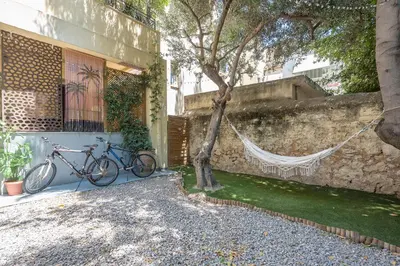 two bikes parked next to a building with a tree at Athens Country House - Heated Jacuzzi - free bikes in Athens
