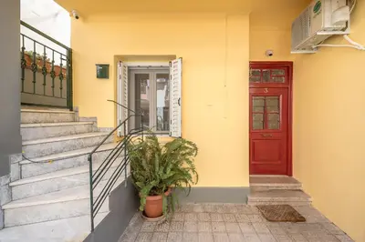 a yellow house with a red door and a plant at Athens Country House - Heated Jacuzzi - free bikes in Athens