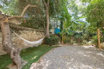 a hammock hanging from a tree in a garden at Athens Country House - Heated Jacuzzi - free bikes in Athens