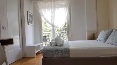 a bedroom with a bed and a large window at Orange Apartment - Athens Center, 3 BD, 1.5 BATH in Athens