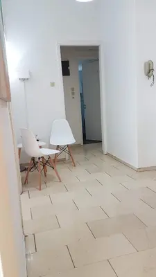 a room with two chairs and a table on a tile floor at Orange Apartment - Athens Center, 3 BD, 1.5 BATH in Athens
