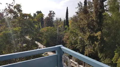 a balcony with a blue railing and trees at Orange Apartment - Athens Center, 3 BD, 1.5 BATH in Athens