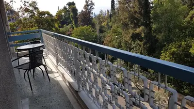 a table and a chair sitting on a balcony at Orange Apartment - Athens Center, 3 BD, 1.5 BATH in Athens