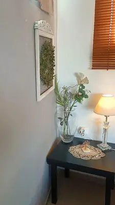 a table with a vase and a lamp on it at Casa Martina 2 (Spata) 10min El.Venizelos airport. in Spáta