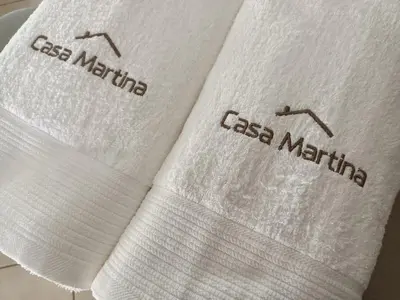 two white towels with the words less medicine on them at Casa Martina 2 (Spata) 10min El.Venizelos airport. in Spáta