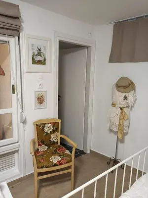 a room with a rocking chair and a window at Casa Martina 2 (Spata) 10min El.Venizelos airport. in Spáta