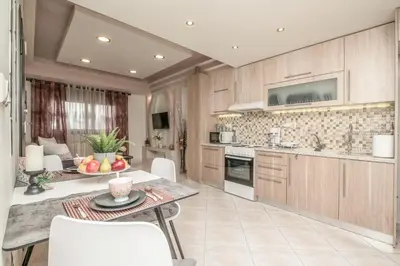 a kitchen with a table and chairs in a room at The Ivory - Luxury & Spacious Apartment in Egaleo-Athens in Athens