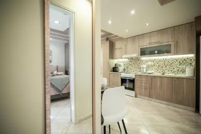 a kitchen with wooden cabinets and a table and chairs at The Ivory - Luxury & Spacious Apartment in Egaleo-Athens in Athens