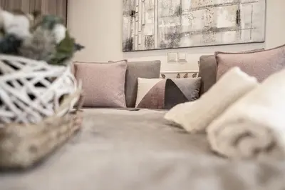 a living room with a couch and a table with pillows at The Ivory - Luxury & Spacious Apartment in Egaleo-Athens in Athens