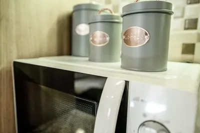 three coffee cups sitting on top of a microwave at The Ivory - Luxury & Spacious Apartment in Egaleo-Athens in Athens