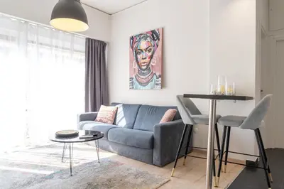a living room with a blue couch and a table at Acropolis Sweet House 4 in Athens
