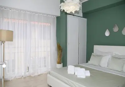 a bedroom with a white bed and a window at Acropolis Sweet House 4 in Athens