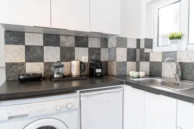 a white kitchen with a sink and a dishwasher at Acropolis Sweet House 4 in Athens
