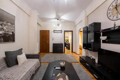 a living room with a couch and a clock on the wall at 2bed renovated flat close to Ampelokipoi metro in Athens