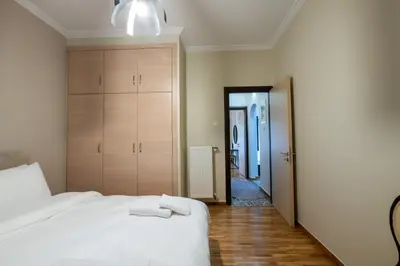 a bedroom with a white bed and a hallway at 2bed renovated flat close to Ampelokipoi metro in Athens