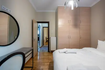 a bedroom with a white bed and a mirror at 2bed renovated flat close to Ampelokipoi metro in Athens
