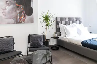 a bedroom with a bed and two chairs and a table at Monastiraki Sweet House 1 in Athens