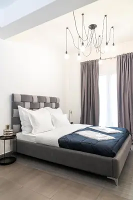 a bedroom with a bed and a chandelier at Monastiraki Sweet House 1 in Athens