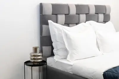 a bedroom with a bed with white pillows and a side table at Monastiraki Sweet House 1 in Athens