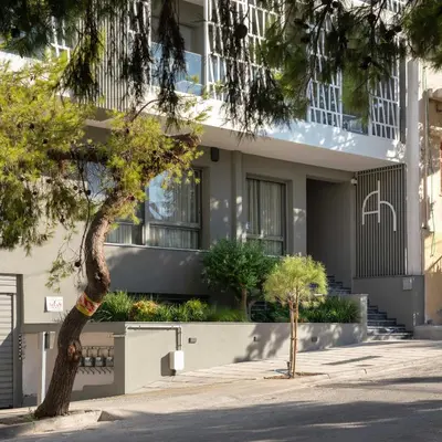 a building with a tree in front of it at Athens Hill Luxury Apartments in Athens
