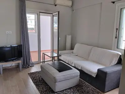 a living room with a couch and a tv at Roofgarden Apartment in Athens