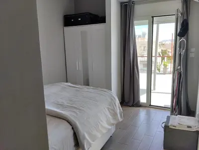 a bedroom with a bed and a door to a balcony at Roofgarden Apartment in Athens