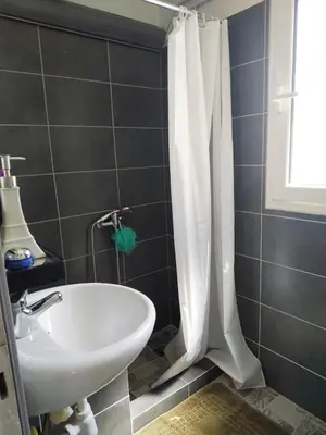 a bathroom with a white shower curtain and a sink at Roofgarden Apartment in Athens