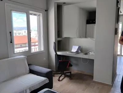 a living room with a couch and a desk with a laptop at Roofgarden Apartment in Athens