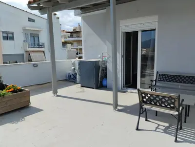 a patio with a bench on a balcony at Roofgarden Apartment in Athens
