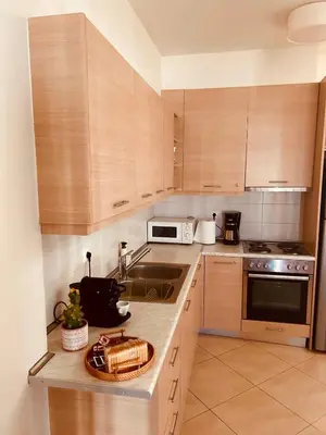 a kitchen with wooden cabinets and a counter top at Central & Comfortable, with Acropolis view in Athens