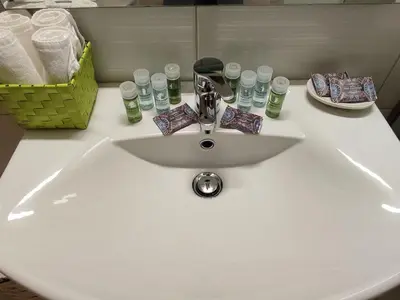 a bathroom sink with a faucet and a basket of glasses at Central & Comfortable, with Acropolis view in Athens