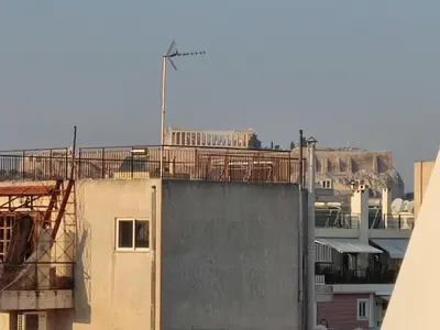 a building with a wind turbine on top of it at Central & Comfortable, with Acropolis view in Athens