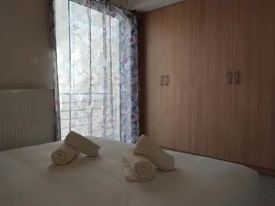 a bedroom with two towels on a bed with a window at Central & Comfortable, with Acropolis view in Athens