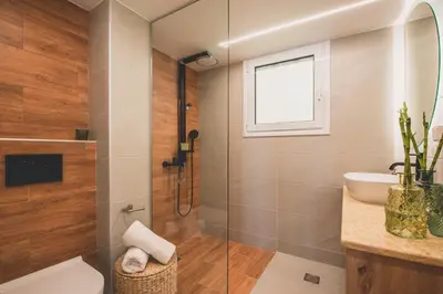 a bathroom with a shower and a toilet and a sink at Luxury Apartment with Acropolis View Terrace and Jacuzzi - Living Stone Moonstone in Athens