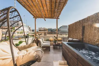 a balcony with a tub and chairs and a table at Luxury Apartment with Acropolis View Terrace and Jacuzzi - Living Stone Moonstone in Athens