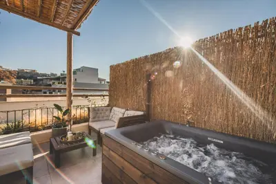a hot tub on a balcony with a fence at Luxury Apartment with Acropolis View Terrace and Jacuzzi - Living Stone Moonstone in Athens