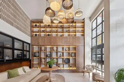 a living room with a table and a wall of shelves at Anise Aluma Athens, Tapestry Collection by Hilton in Athens