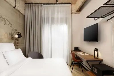 a bedroom with a bed and a desk and a television at Anise Aluma Athens, Tapestry Collection by Hilton in Athens