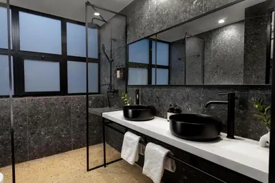 a black bathroom with two sinks and mirrors at Anise Aluma Athens, Tapestry Collection by Hilton in Athens