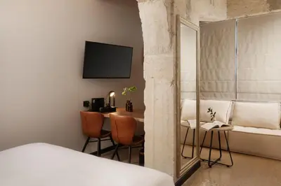 a bedroom with a bed and a table with a mirror at Anise Aluma Athens, Tapestry Collection by Hilton in Athens