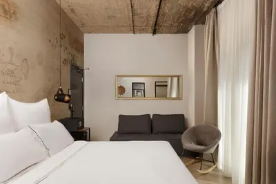 a bedroom with a white bed and a couch at Anise Aluma Athens, Tapestry Collection by Hilton in Athens
