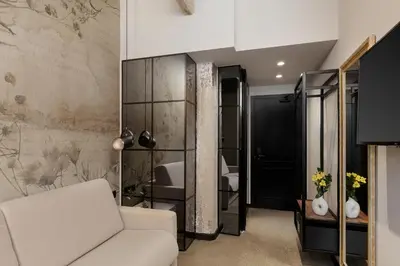 a living room with a white couch and a bedroom at Anise Aluma Athens, Tapestry Collection by Hilton in Athens
