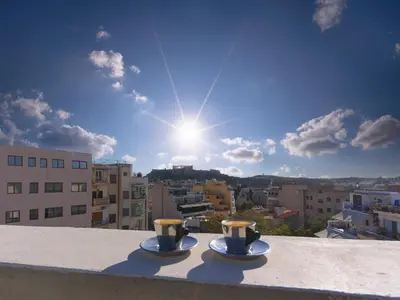 two cups on a ledge with a view of a city at Eastern Aromas loft in Psyri, Athens in Athens