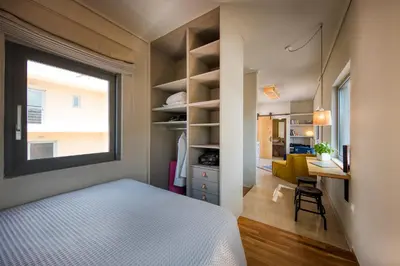 a bedroom with a bed and a window and a desk at Sunny Loft with Acropolis View in Athens