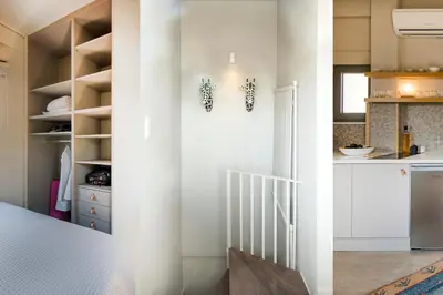 a kitchen with white cabinets and a staircase at Sunny Loft with Acropolis View in Athens